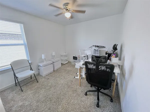a view of a workspace with furniture and a window