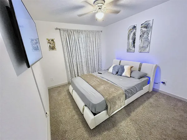 a bedroom with a bed and a flat screen tv