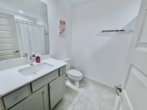 a bathroom with a sink vanity mirror and toilet