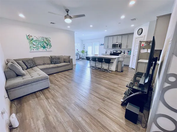a living room with furniture and wooden floor