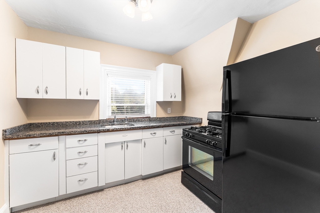 131 Irving Avenue, Unit 3 Providence, RI 02906 - Photo 11 of 14 a kitchen with granite countertop cabinets stainless steel appliances and a window