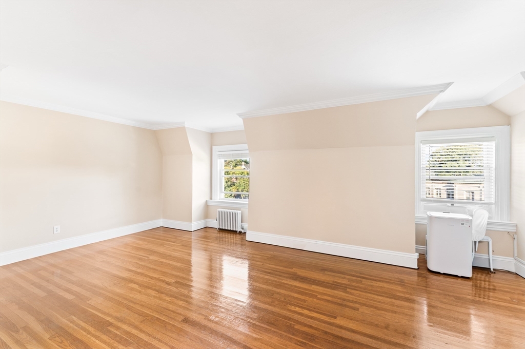 131 Irving Avenue, Unit 3 Providence, RI 02906 - Photo 9 of 14 an empty room with wooden floor and windows