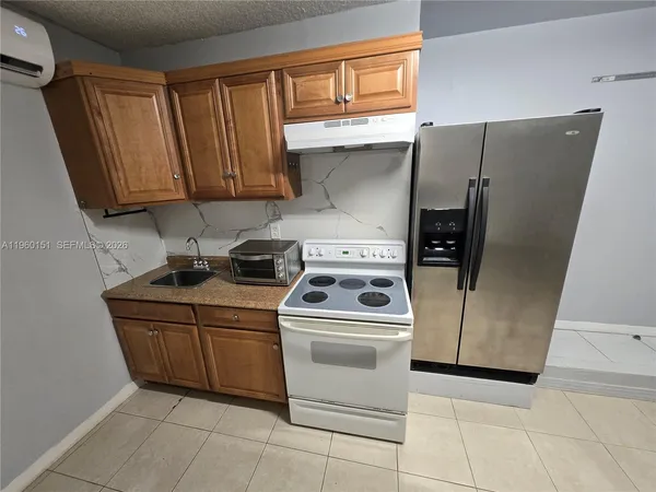 a kitchen with a stove top oven and cabinets