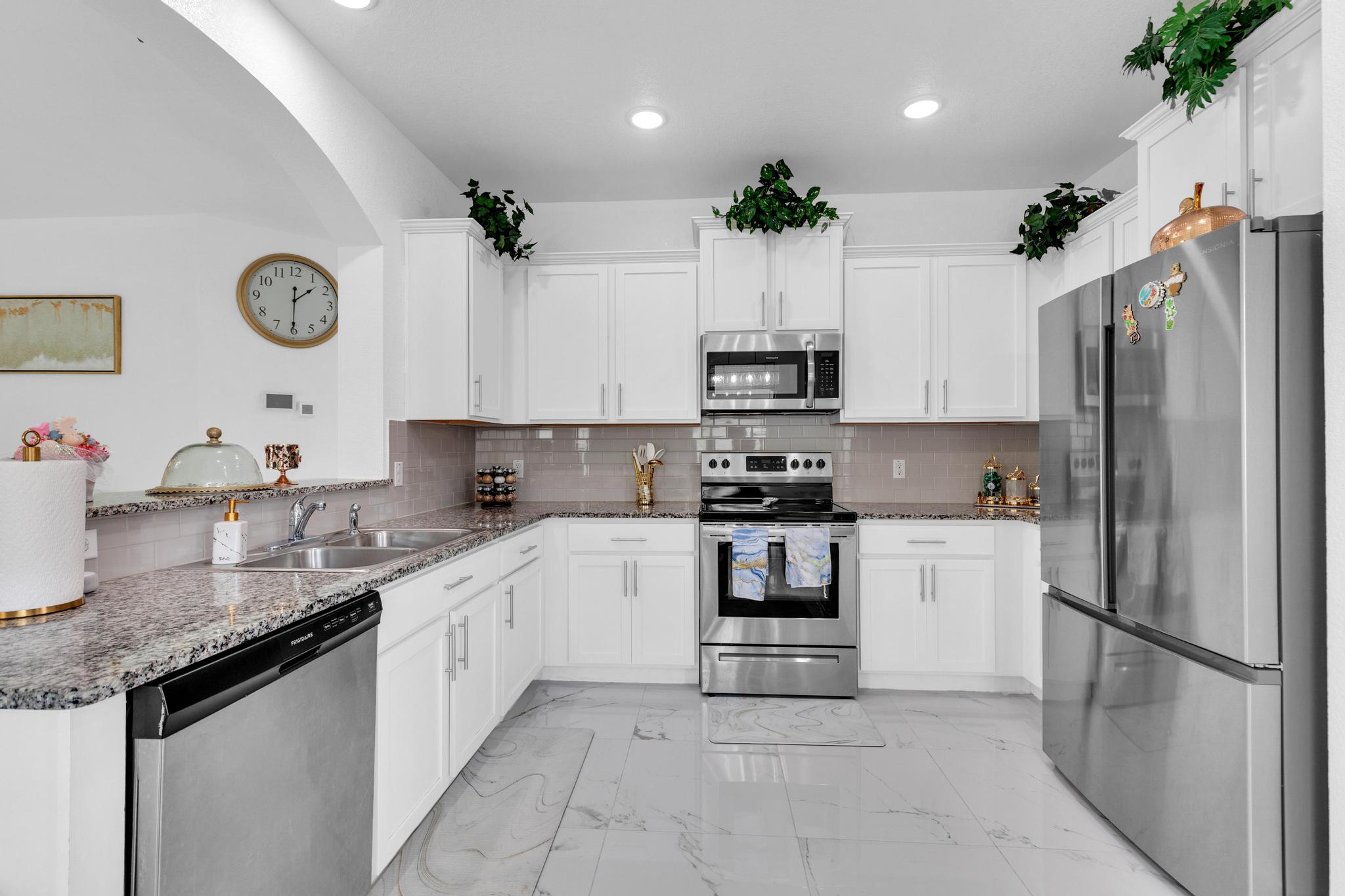 119 Beth Ann Loop Taylor, TX 76574 - Photo 15 of 31 A well-lit culinary space showcases pristine white cabinetry and sleek stainless steel appliances.