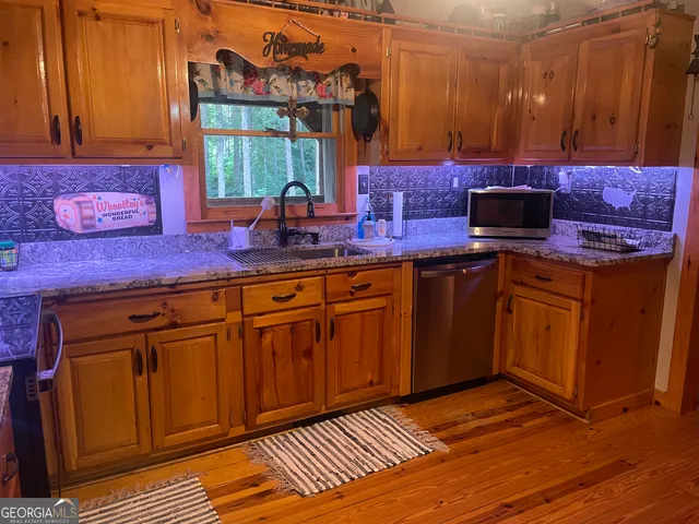 a kitchen with stainless steel appliances wooden cabinets and a stove top oven