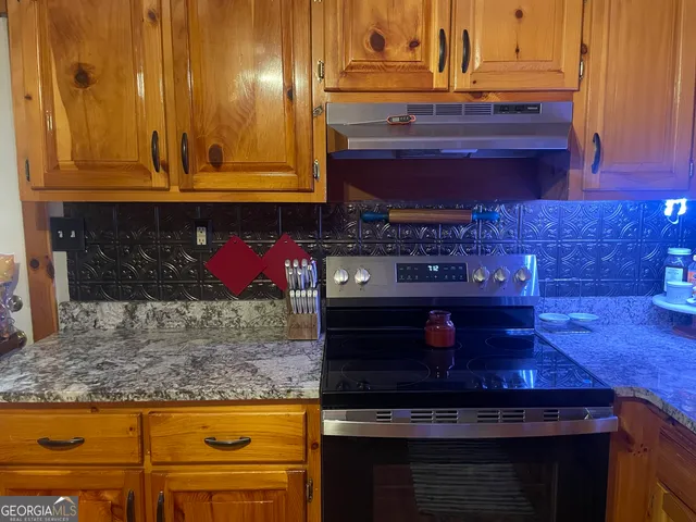 a kitchen with stainless steel appliances granite countertop wooden cabinets and a counter top