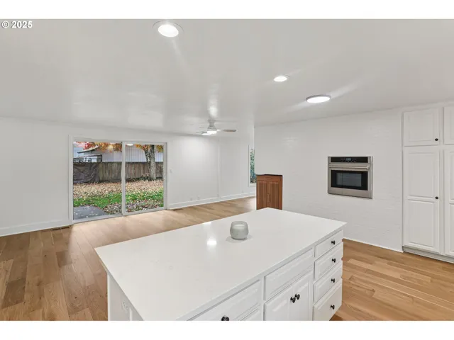 a large kitchen with granite countertop a sink and cabinets