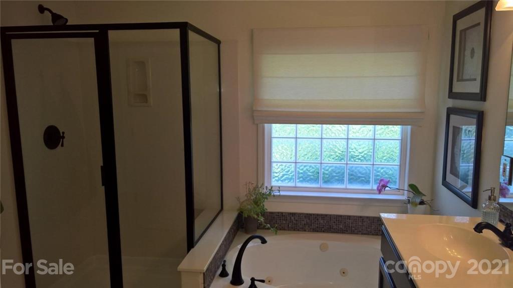 311 Matthews Estates Road Matthews, NC 28105 - Photo 20 of 27 a bathroom with a tub a sink and a window