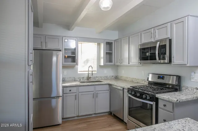 a kitchen with stainless steel appliances granite countertop a refrigerator stove a sink and a microwave