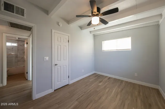 a view of empty room with wooden floor