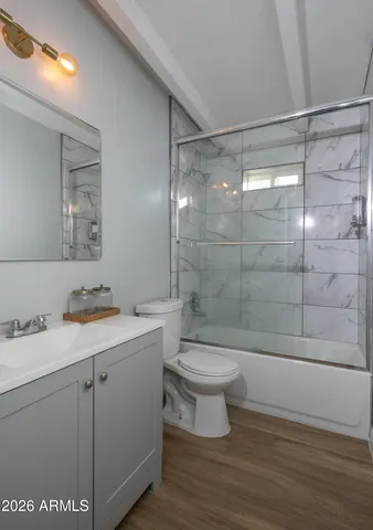 a bathroom with a bathtub shower sink vanity and toilet