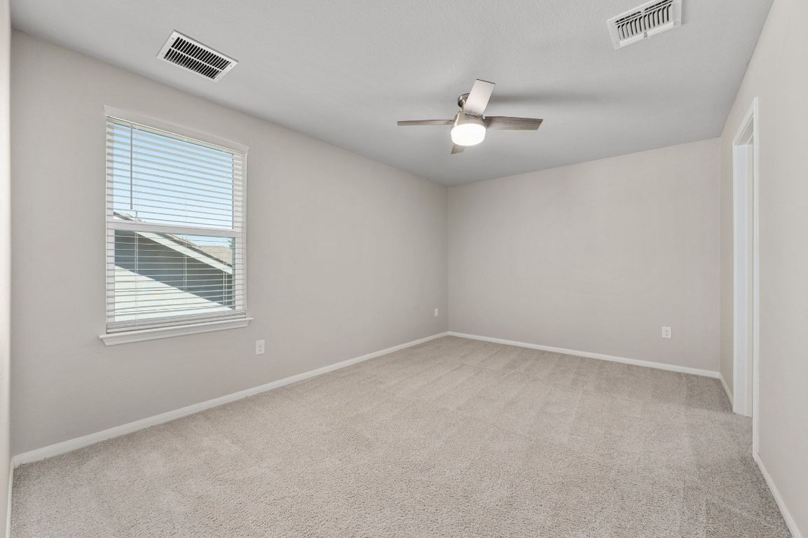 6701 Janes Ranch Road Austin, TX 78744 - Photo 21 of 36 an empty room with a window and ceiling fan