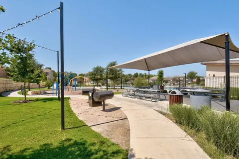 a view of a patio with a table and chairs under an umbrella