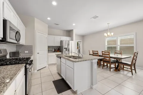 a kitchen with stainless steel appliances kitchen island granite countertop a stove a sink and a refrigerator