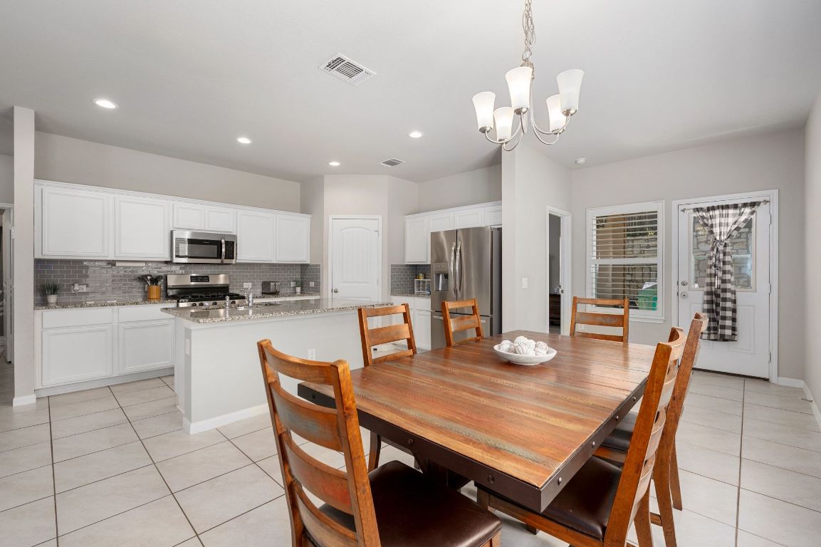 6701 Janes Ranch Road Austin, TX 78744 - Photo 9 of 36 a dining room with stainless steel appliances granite countertop a dining table and chairs