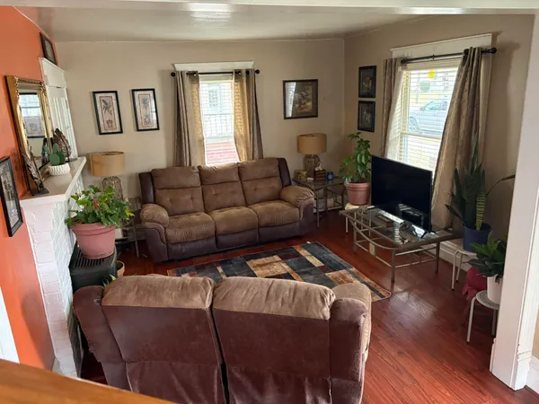 a living room with furniture a flat screen tv and a window