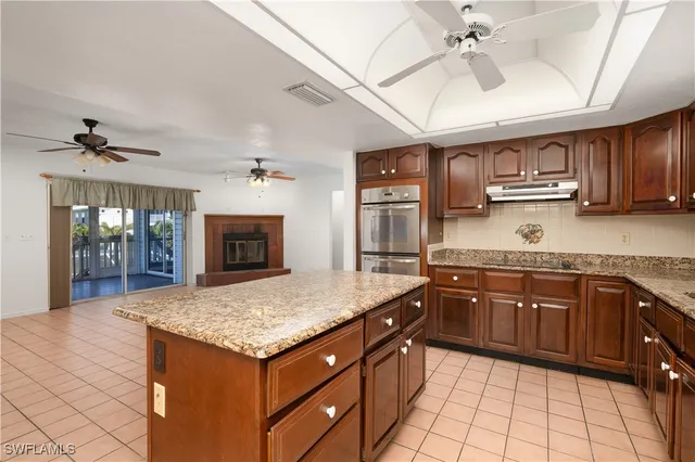 a kitchen with stainless steel appliances granite countertop a sink dishwasher stove and refrigerator with wooden floor