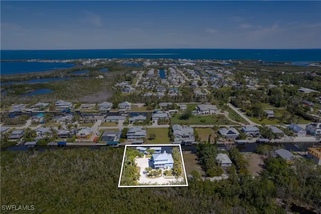 an aerial view of residential houses with outdoor space and lake view