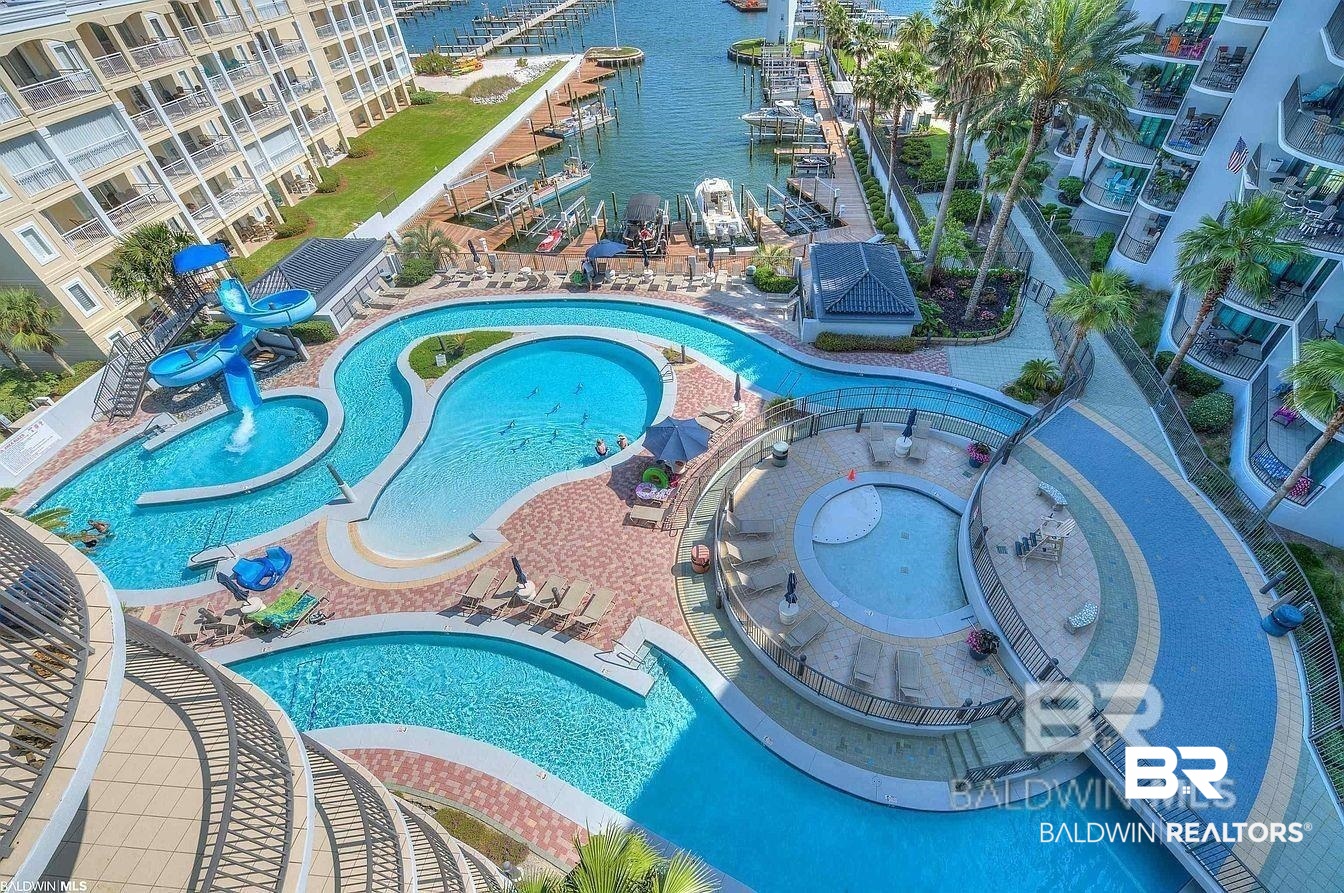 27582 Canal Road, Unit 2611 Orange Beach, AL 36561 - Photo 3 of 37 Community pool with a water slide, a water view, and a water play area