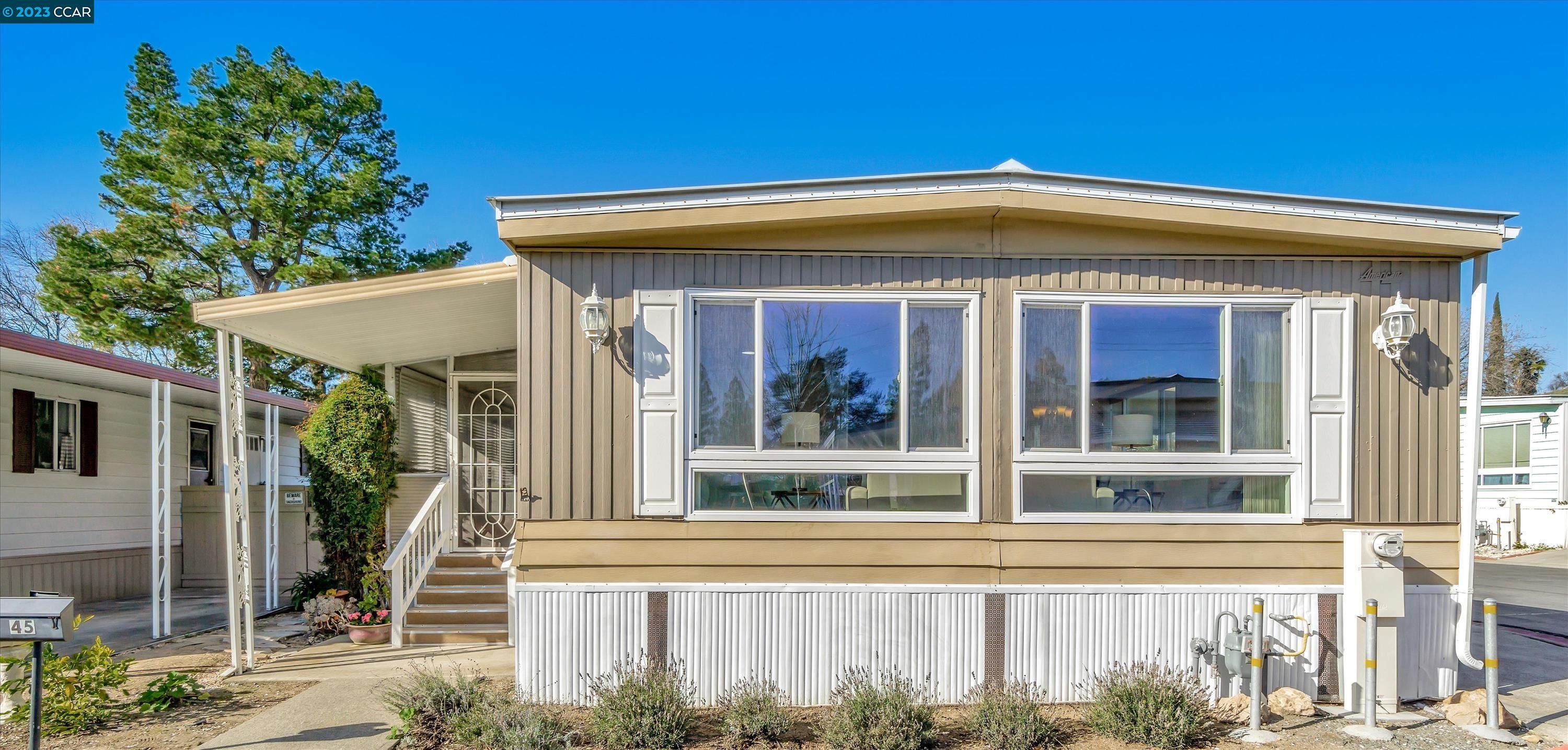 a view of a house with a large window and plants
