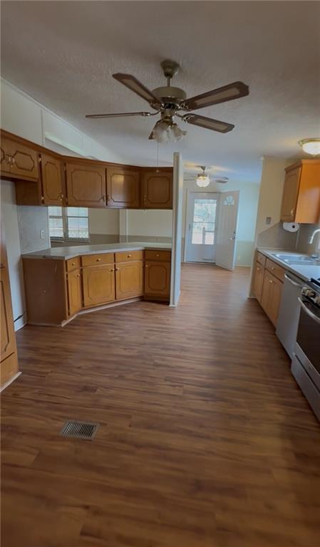 129 Bishop Road Smiths Station, AL 36877 - Photo 12 of 24 Kitchen with dark wood finished floors, stainless steel appliances, light countertops, wood finish cabinets, and a textured ceiling