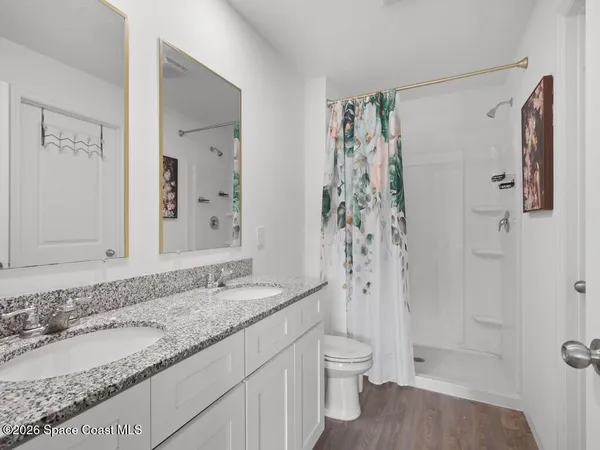 a bathroom with a granite countertop sink toilet and shower