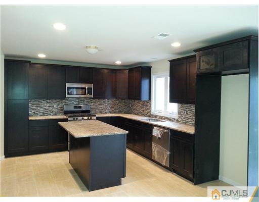 60 Sturgis Road Edison, NJ 08817 - Photo 3 of 5 a kitchen with stainless steel appliances kitchen island granite countertop a sink counter space and cabinets