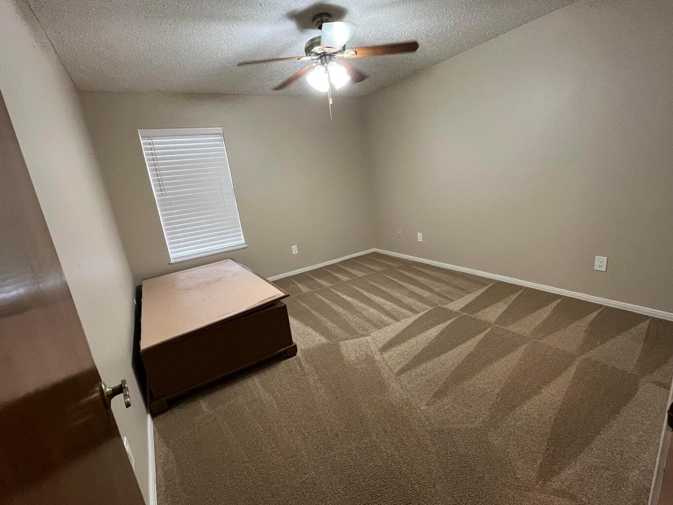 1312 Yonkers Street Plainview, TX 79072 - Photo 17 of 25 a bedroom with a bed and a ceiling fan