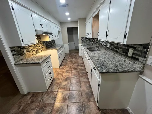 a kitchen with sink stove and cabinets