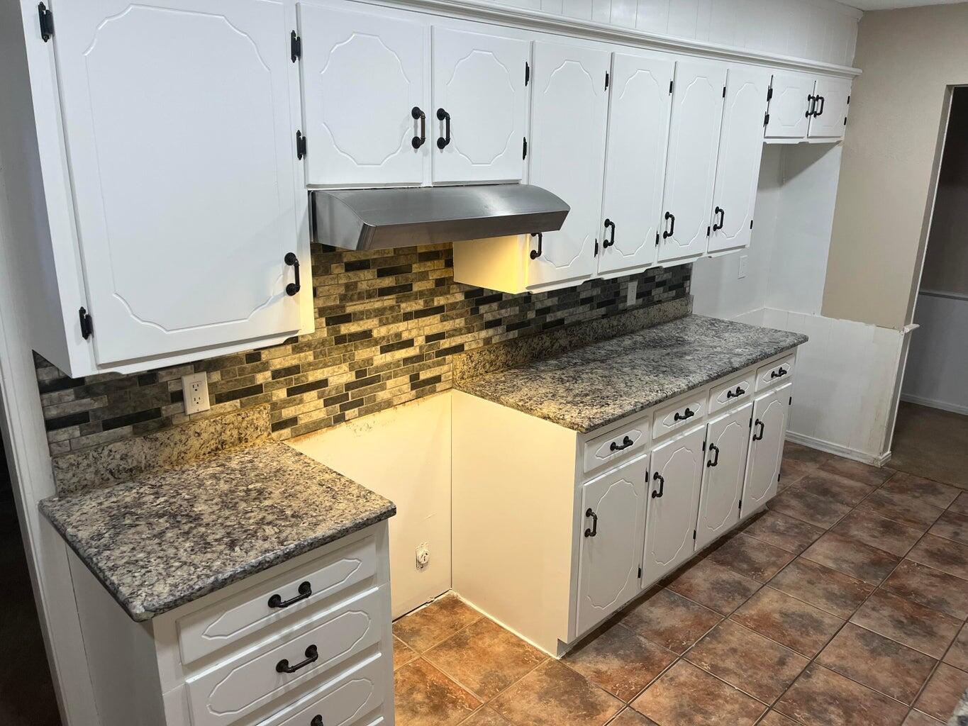 1312 Yonkers Street Plainview, TX 79072 - Photo 8 of 25 a kitchen with stainless steel appliances granite countertop a sink stove and cabinets