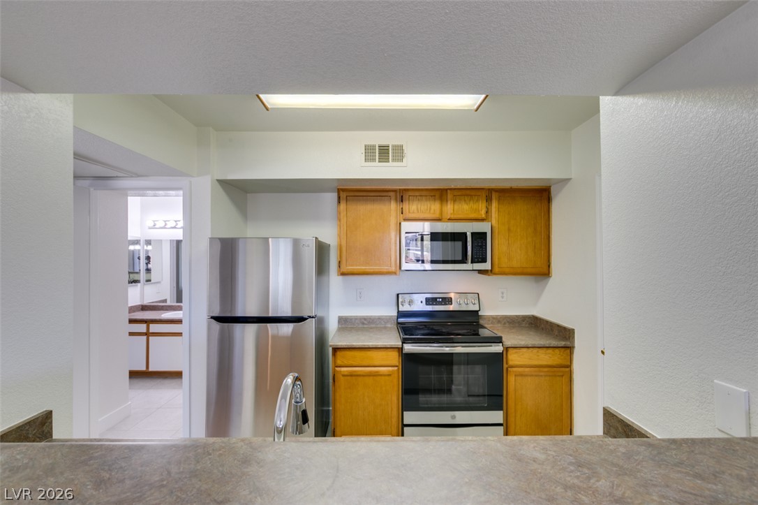 6650 West Warm Springs Road, Unit 2118 Las Vegas, NV 89118 - Photo 12 of 41 A well-appointed kitchen showcasing contemporary stainless steel appliances and warm wood cabinetry.