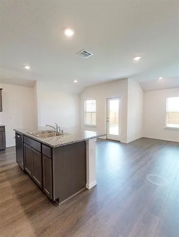 an empty room with wooden floor and window