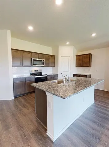 a kitchen with stainless steel appliances granite countertop a sink stove and microwave