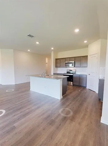 a large kitchen with stainless steel appliances granite countertop a large counter top and a stove top oven