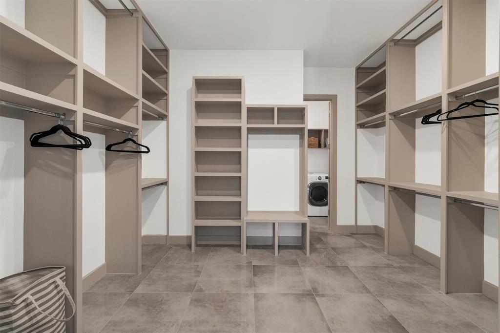 7519 Robin Road Dallas, TX 75209 - Photo 20 of 33 Built-in closet system with shelving and hanging rods, center storage unit, and tile flooring