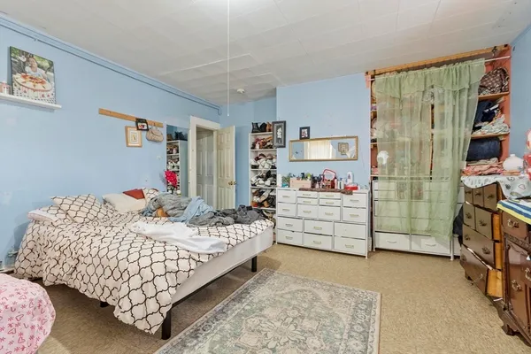 a bedroom with bed and a book shelf