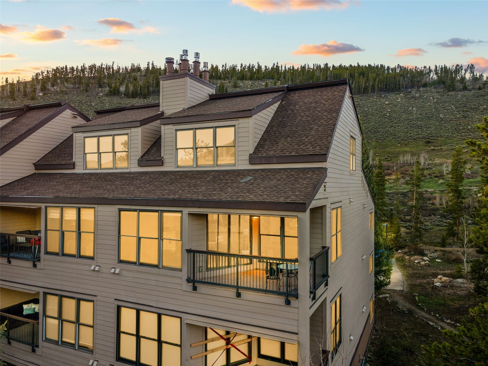 240 Tennis Club Road, Unit 1677 Keystone, CO 80435 - Photo 1 of 46 Back of property at dusk featuring roof with shingles, a balcony, and a chimney