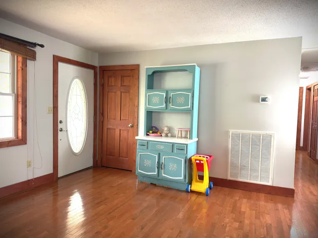 a view of a hallway with wooden floor and stairs