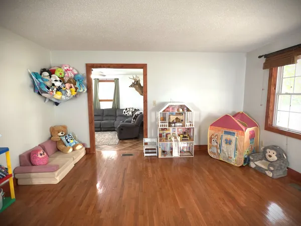 a view of a bedroom with furniture and wooden floor