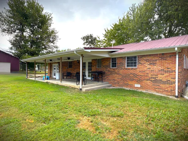 a view of a porch with furniture and a yard