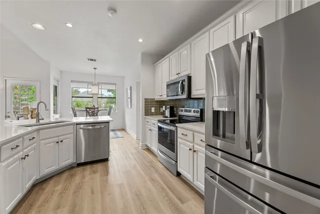 a kitchen with stainless steel appliances a refrigerator sink and microwave