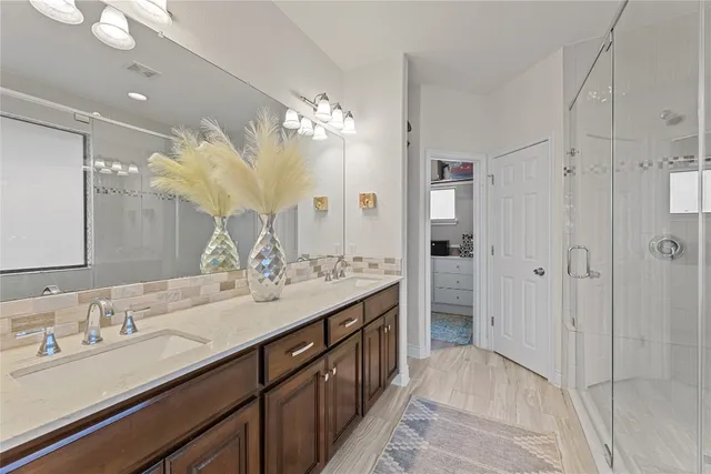 a spacious bathroom with a double vanity sink shower and a mirror