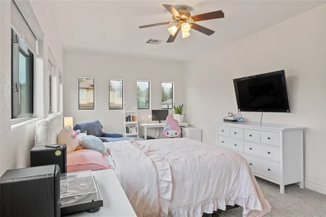 a bed room with a bed and a flat tv screen on dresser