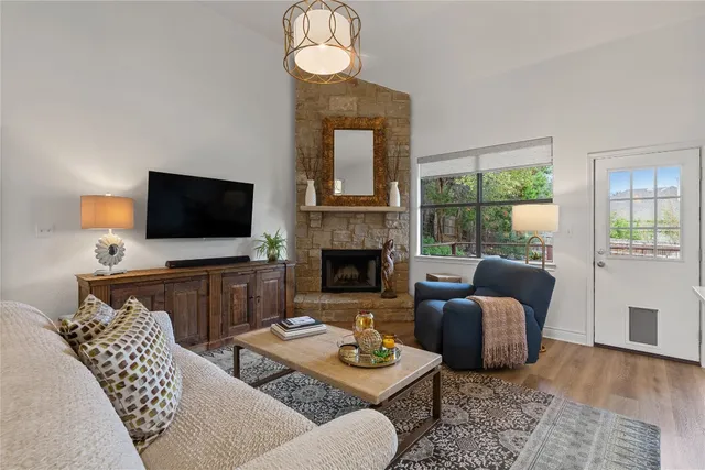 a living room with furniture a flat screen tv and a fireplace