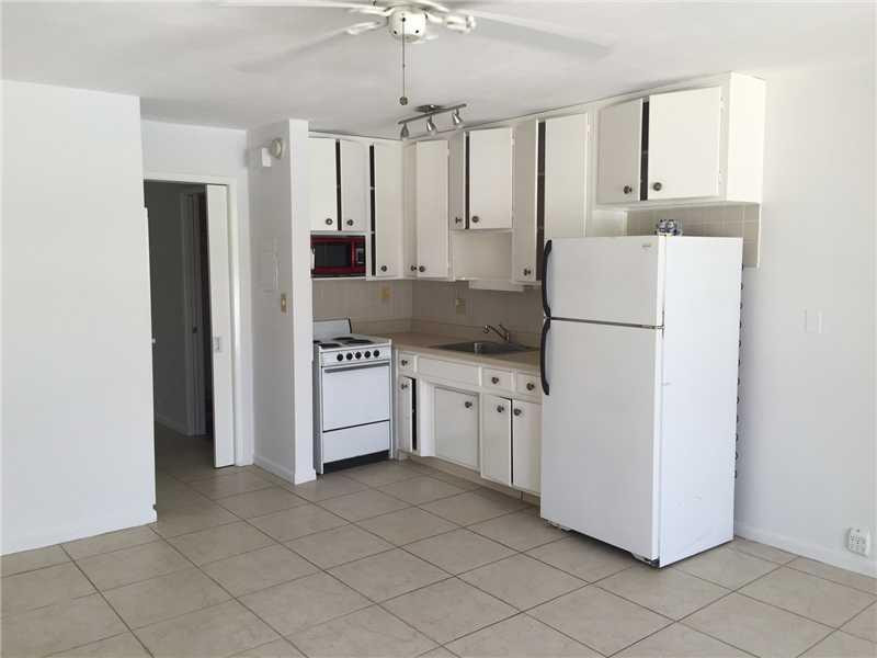 901 North Birch Road, Unit 5B Fort Lauderdale, FL 33304 - Photo 3 of 12 a kitchen with cabinets and a refrigerator