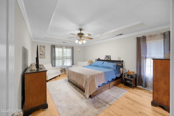 a spacious bedroom with a bed and a chandelier