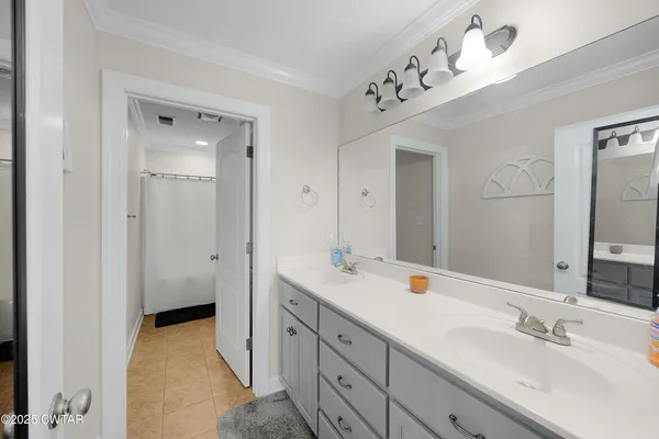 a spacious bathroom with a double vanity sink a mirror and shower