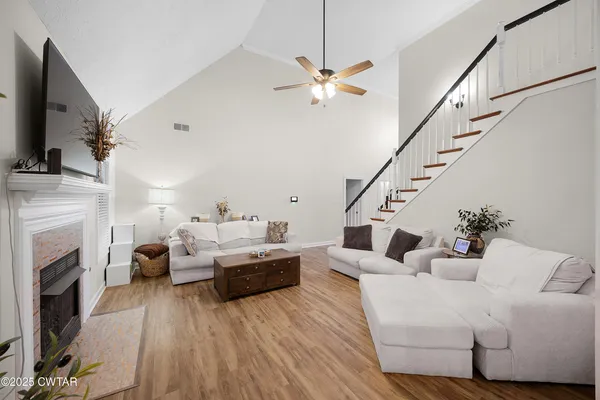 a living room with furniture a fireplace and a flat screen tv