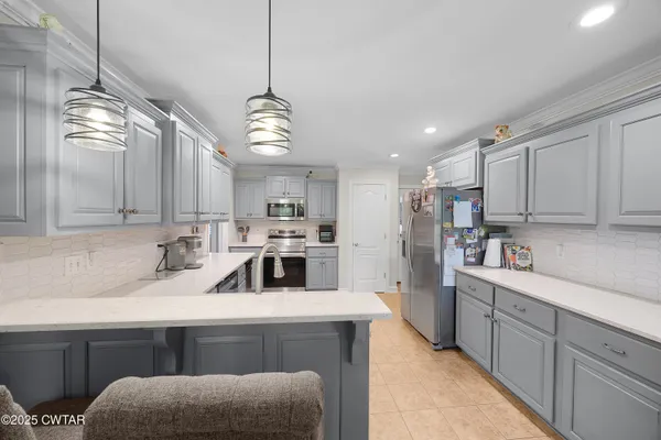 a kitchen with stainless steel appliances granite countertop a sink a stove and a refrigerator