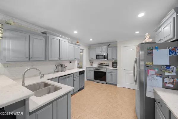 a kitchen with white cabinets and stainless steel appliances